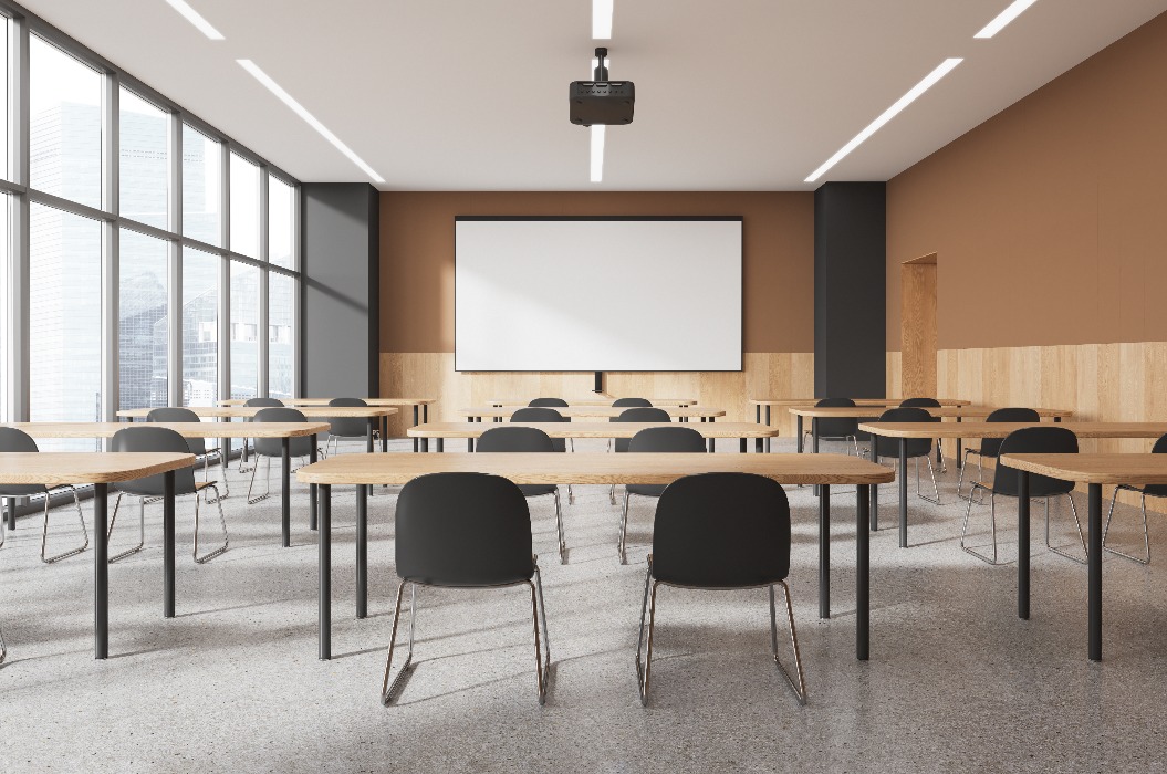 Beige und graue Klassenzimmereinrichtung mit Projektionsfläche